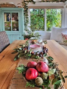 a wooden table topped with fruit and veggies on top of a wooden dining room table