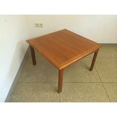 a wooden table sitting on top of a tiled floor