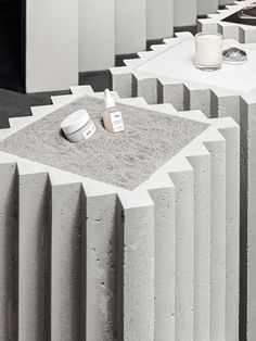 concrete blocks are arranged in the shape of an abstract structure with a candle and salt shaker on top