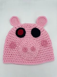 a crocheted pig hat with big eyes