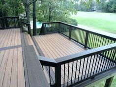 a wooden deck with black rails and railings