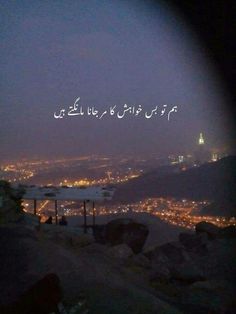 the city lights in the distance are lit up at night with arabic writing on it