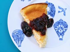 a piece of blueberry cheesecake on a white and blue plate with blue designs