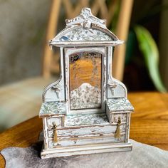 an old clock sitting on top of a wooden table