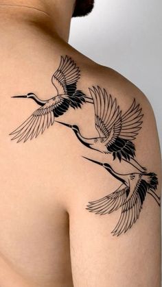 the back of a man's shoulder with two birds on it