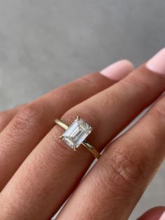 a woman's hand with an engagement ring on it and a diamond in the middle