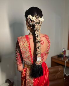 the back of a woman's head wearing a red and gold bridal gown