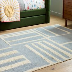 a blue and white rug in front of a green couch