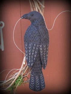 a blue bird sitting on top of a tree branch next to a red wall with white writing