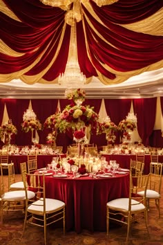 a banquet room with red drapes, gold chandelier and floral centerpieces