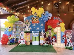 an indoor area decorated with balloons and decorations for a toy story birthday party at the children's museum