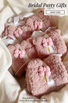 pink teddy bears are wrapped in white ribbon and tied with bows on top of each other