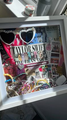 a white frame with sunglasses and other items in it