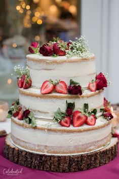 a three tiered cake with strawberries on top