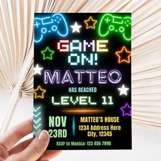 a hand holding up a card with the game on mateo level 11 written in neon colors