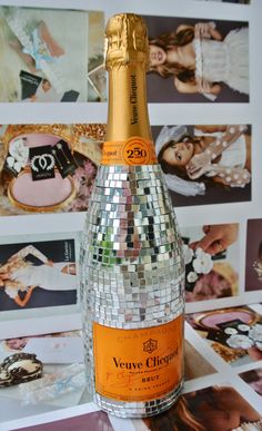 a bottle of champagne sitting on top of a table next to pictures and magnets