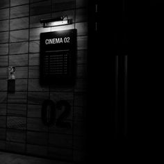 a black and white photo of a wall with a sign that says cinema 02 on it