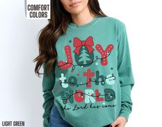 You will love our Comfort Colors Christmas long sleeve t shirt for Christians. It says, Joy to the World the Lord has come in a retro colorful font. This long sleeve holiday tee would make a great gift for a Christian who loves Christmas. It comes in 6 beautiful Comfort Colors brand t shirt colors, ivory, light green, blossom, black, red and white. Stay on trend with this popular Christian holiday t-shirt this winter. ~PRODUCT DETAILS~ -100% ring-spun cotton -Medium fabric (6.1 oz/yd² (206.8 g/m Green Long Sleeve Tops As Gift, Green Long Sleeve T-shirt For Holiday, Holiday Long Sleeve T-shirt With Letter Print, Long Sleeve Graphic Print T-shirt For Holiday, Long Sleeve T-shirt With Text Print For Gift, Text Print Long Sleeve T-shirt For Gifts, Red Long Sleeve T-shirt Gift, Red Long Sleeve T-shirt, Christmas Church