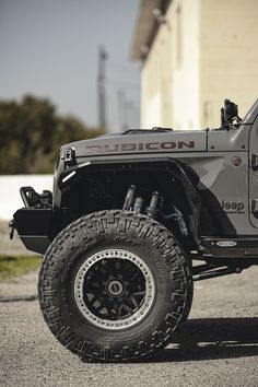 a gray jeep parked in front of a building