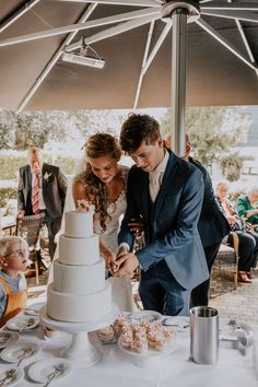 a bride and groom cutting their wedding cake