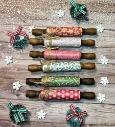 rolled up christmas wrappings on wooden table with snowflakes