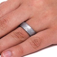 a close up of a person's hand with a wedding ring on their finger