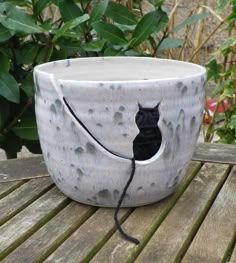 a ceramic cup with a black cat on it