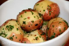 a white bowl filled with potatoes covered in cheese