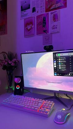 a desktop computer sitting on top of a desk next to a keyboard and mouse in front of a purple wall