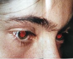 a man with red eyes looking at the camera