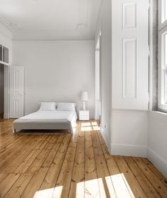 an empty bedroom with white walls and wood floors