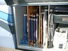 the inside of a storage compartment with baseball bats and other equipment in it, on top of a carpeted floor