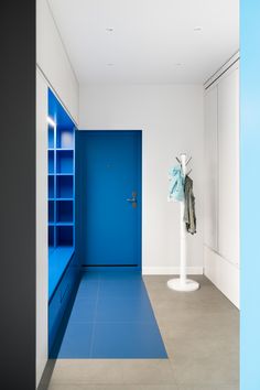 an empty room with a blue door and shelves