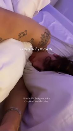 a woman laying in bed with tattoos on her stomach