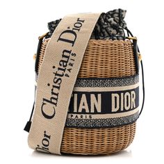 This is an authentic CHRISTIAN DIOR Wicker Oblique Drawstring Bucket Bag in Blue. This small bucket-style bag is crafted of wicker with Dior monogram canvas and blue leather and embroidered Christian Dior logo trim. The bag features an adjustble beige and blue canvas shoulder strap and aged gold hardware. The center canvas interior opens with a cinch cord to a patch pocket. Luxury Woven Leather Straw Bucket Bag, Luxury Straw Bucket Bag With Woven Leather, Luxury Straw Bucket Bag With Bamboo Handle, Luxury Beige Basket Bucket Bag, Designer Woven Leather Bucket Straw Bag, Designer Woven Leather Straw Bucket Bag, Designer Woven Bucket Shoulder Bag, Designer Woven Bucket Bag, Designer Straw Bucket Bag With Braided Handles