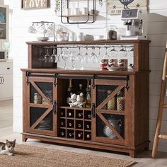 a cat laying on the floor in front of a cabinet with wine glasses and bottles