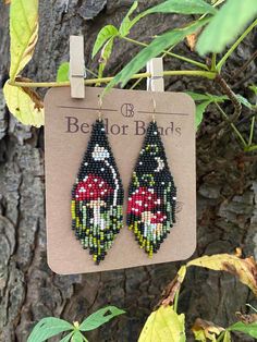 the beaded earrings are hanging from a tree