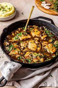 a skillet filled with chicken and mushrooms