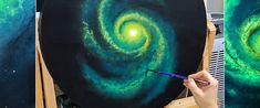 a person is holding a paintbrush in their hand and painting an image of a spiral galaxy