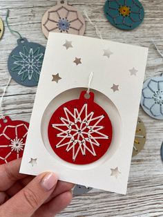 a hand holding a red ornament with white stars on it