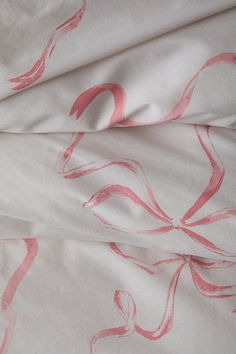 two sheets with pink designs on them are laying next to each other in the bed