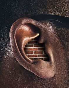 a brick wall with an ear shaped hole in it's center and the words, not something should get in the way of your head