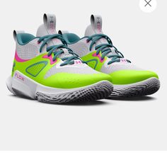 a pair of tennis shoes with neon green and pink accents on the upper part of the shoe