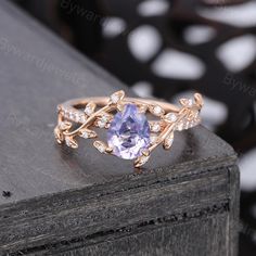 a ring with an amethorate and diamonds on it sitting on top of a table