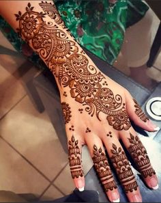 a woman's hand with henna tattoos on it