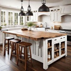 a large kitchen island with stools in front of it and lights hanging from the ceiling