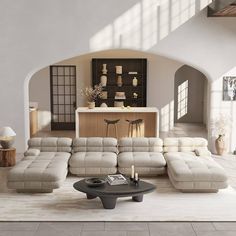 a living room filled with lots of furniture and a large white rug on top of a hard wood floor