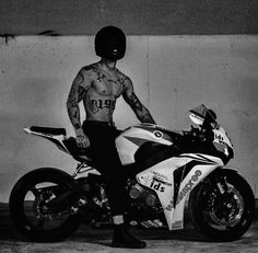 a man with tattoos sitting on a motorcycle