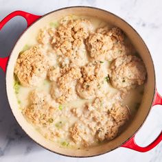 a pot filled with meatballs covered in cheese and broccoli florets