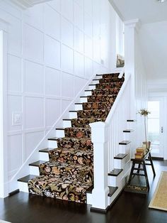 a stair case with floral carpet on the bottom